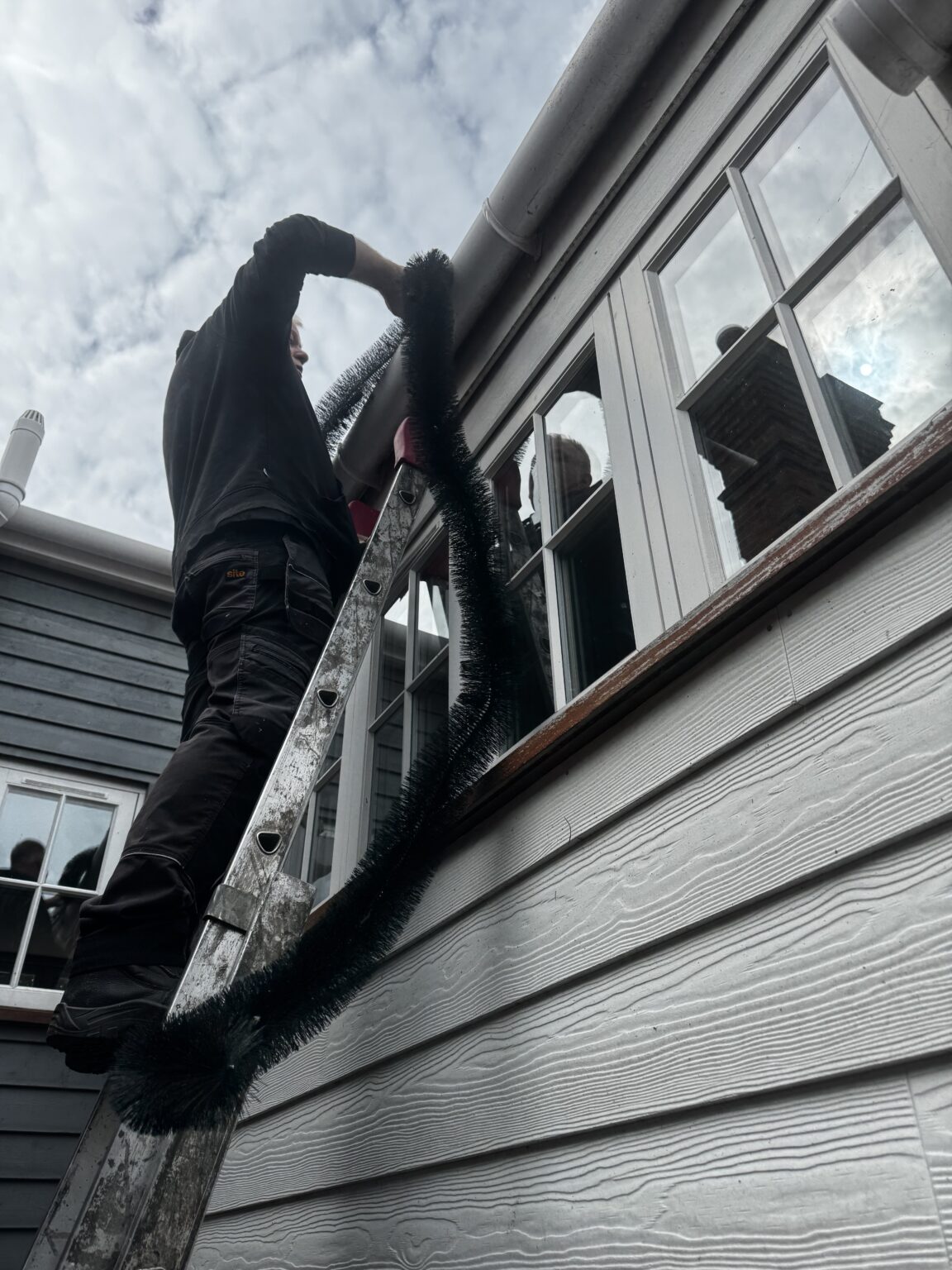 Engineer fitting gutter protection to a period property