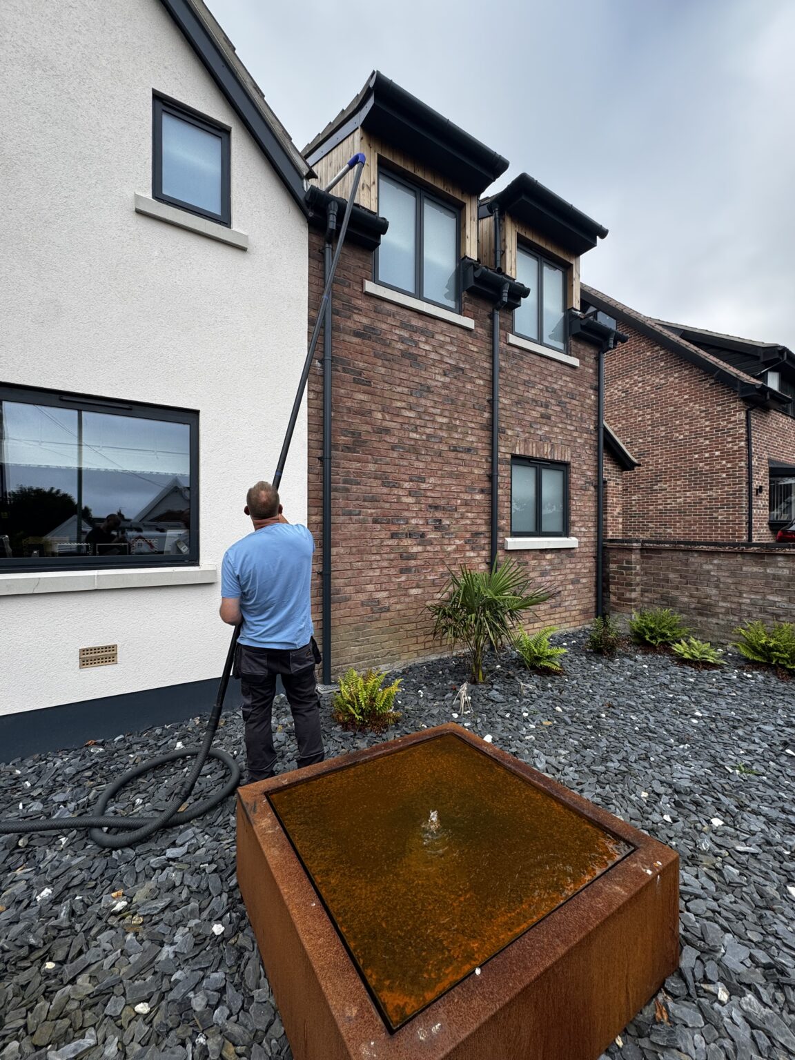 SkyVac vacuum pole clearing a gutter from ground level